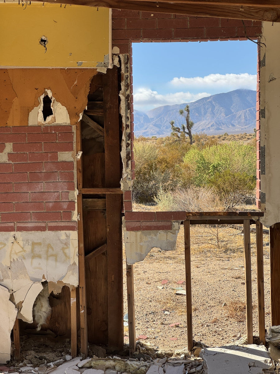Ruins of a building with desert landscape and mountains in the background