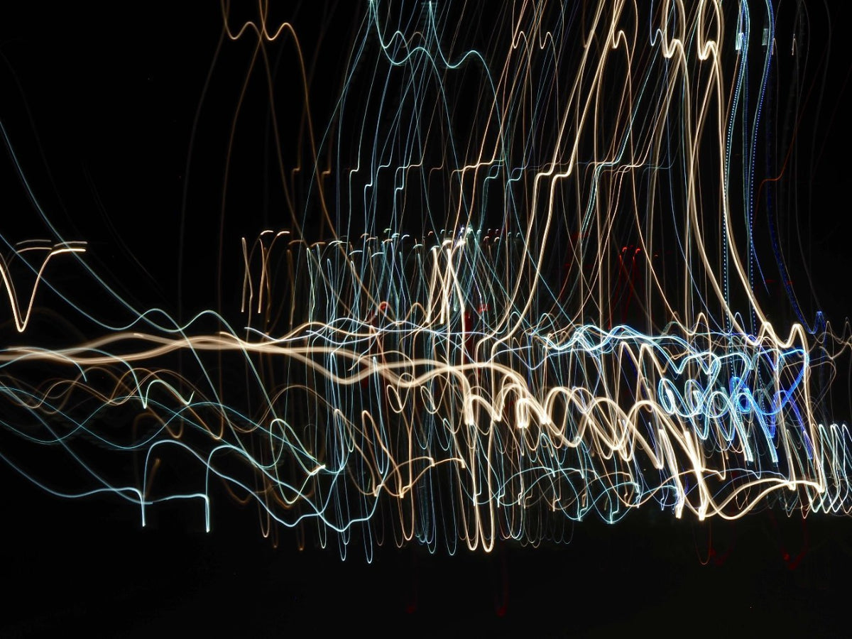 Abstract light tracings resembling dancers in motion against a dark background