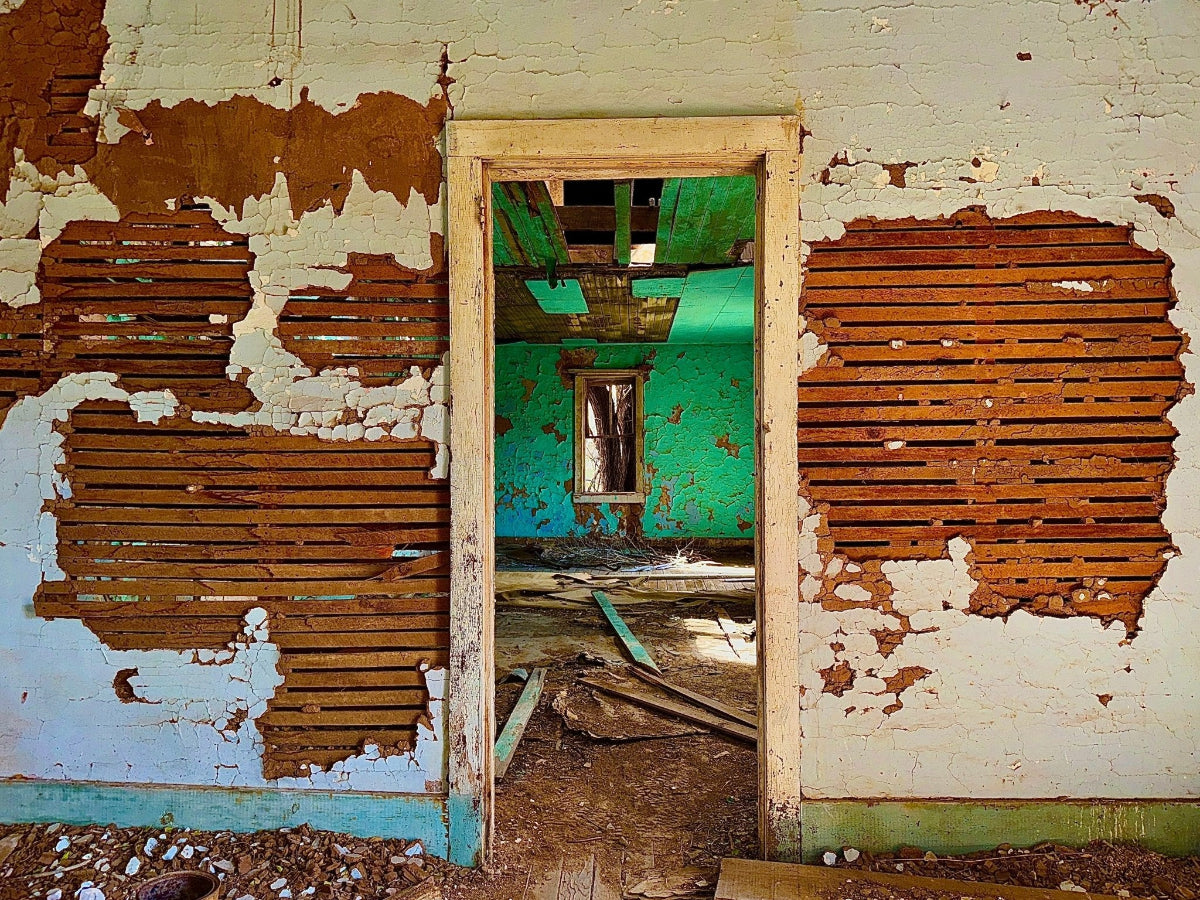 Abandoned room with peeling paint and a green interior.