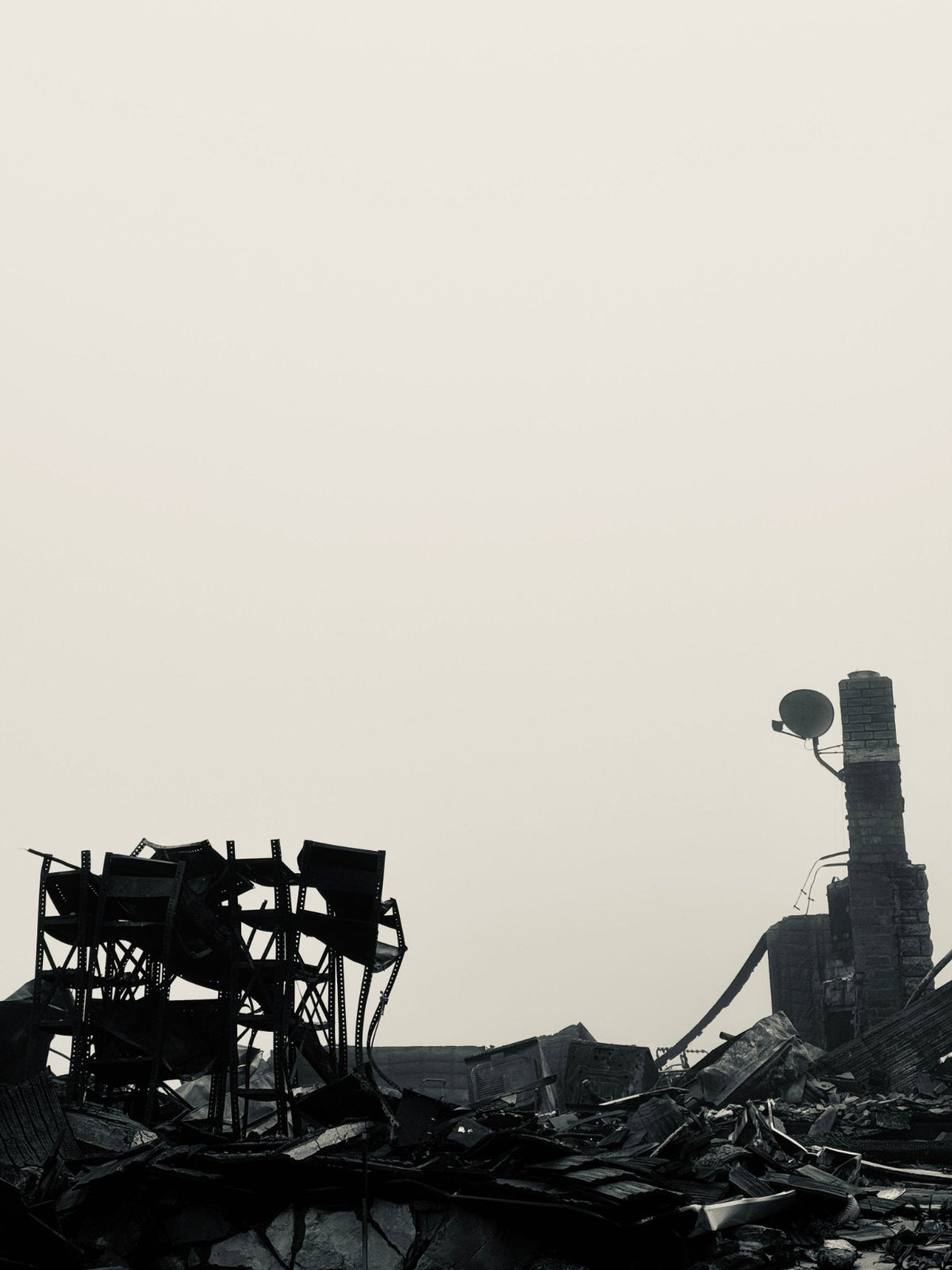Ruins of a building with satellite dish against a gray sky