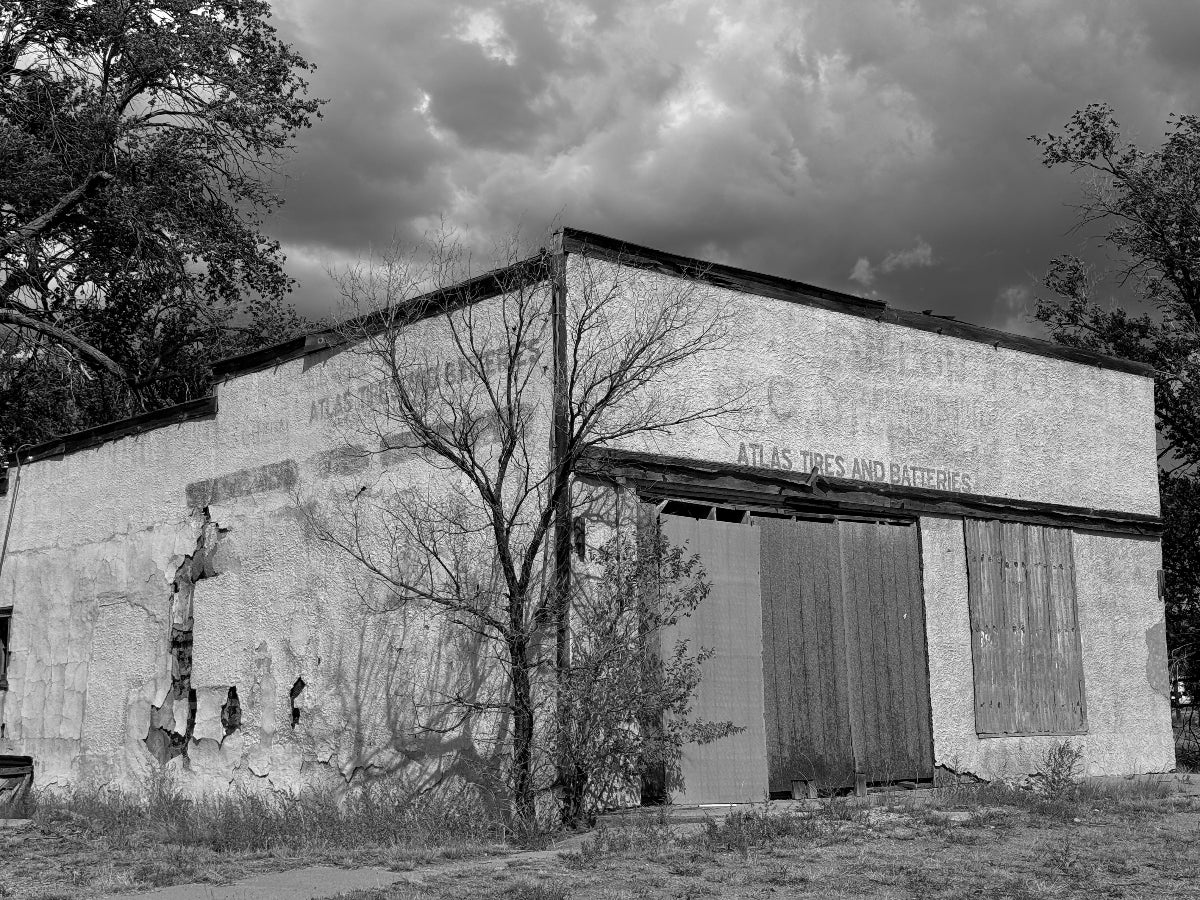Abandoned building with a large sign on a cloudy day