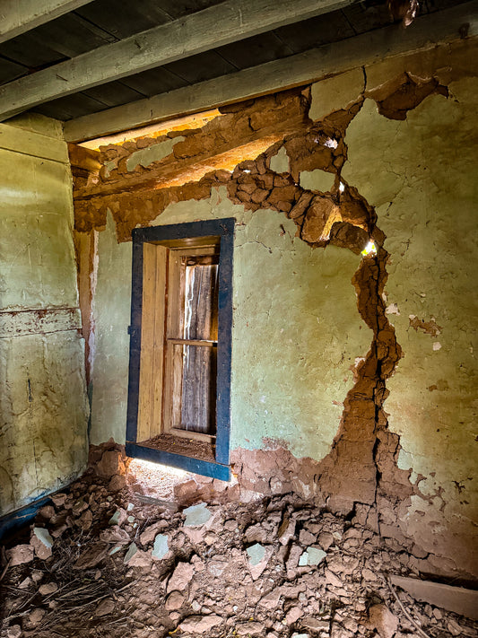 Dilapidated room with a collapsed wall and peeling paint